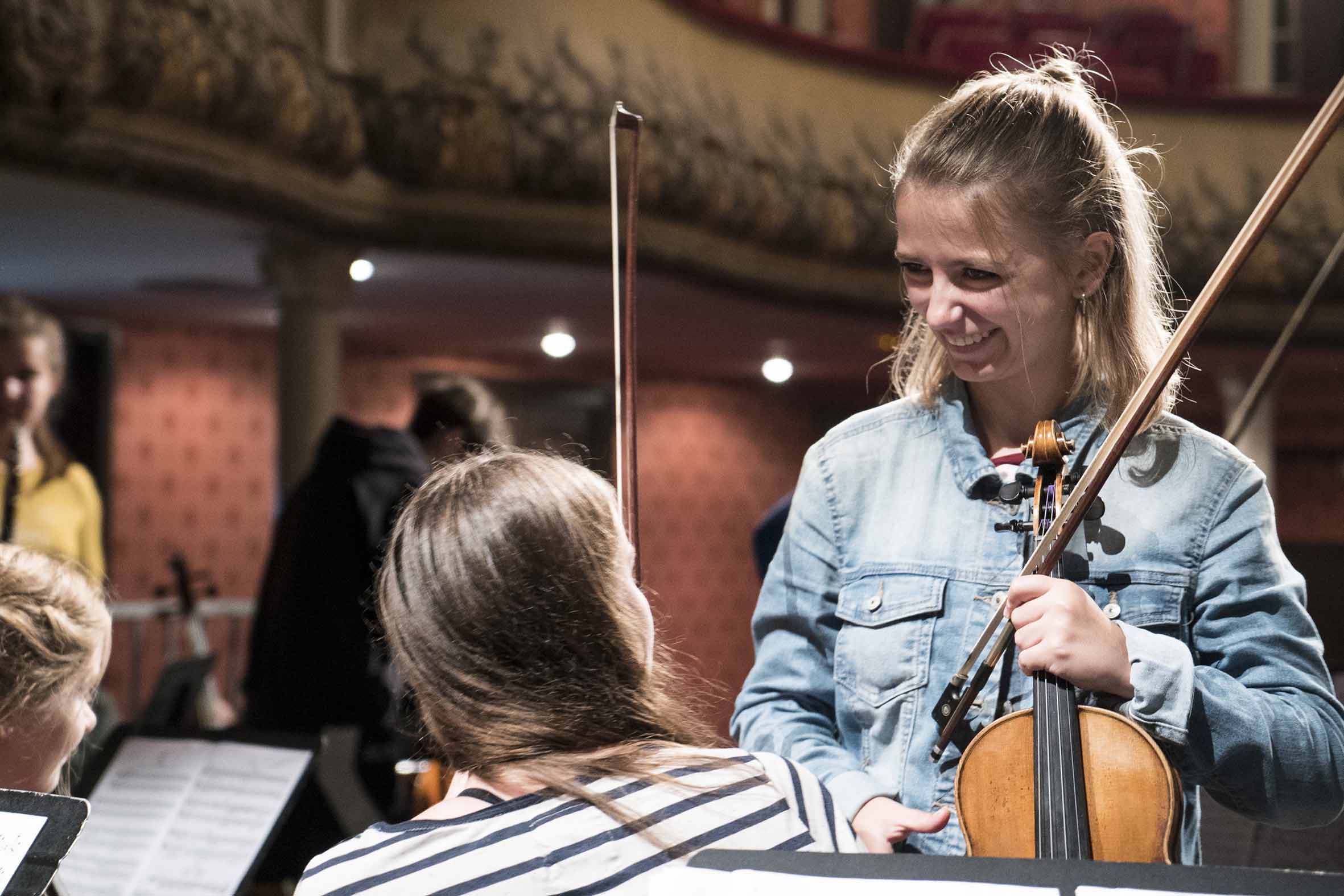 Zwei junge Musikerinnen unterhalten sich im Bezirksjugendsinfonieorchester Unterfranken