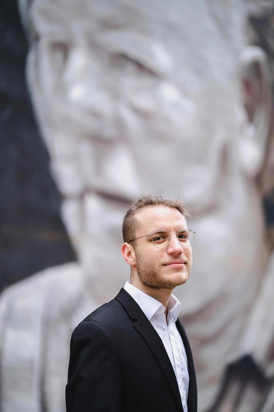 Portrait des Komponisten Felix Linsmeier vor einem Graffito