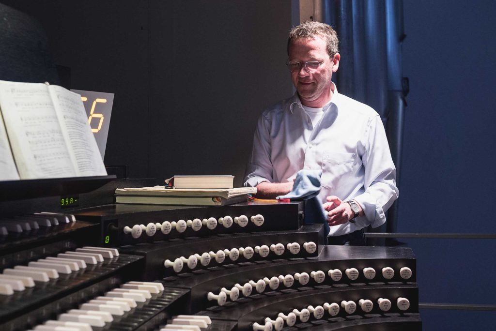 Der Organist wischt während des Gottesdienstes Staub auf der Orgel im Würzburger Dom